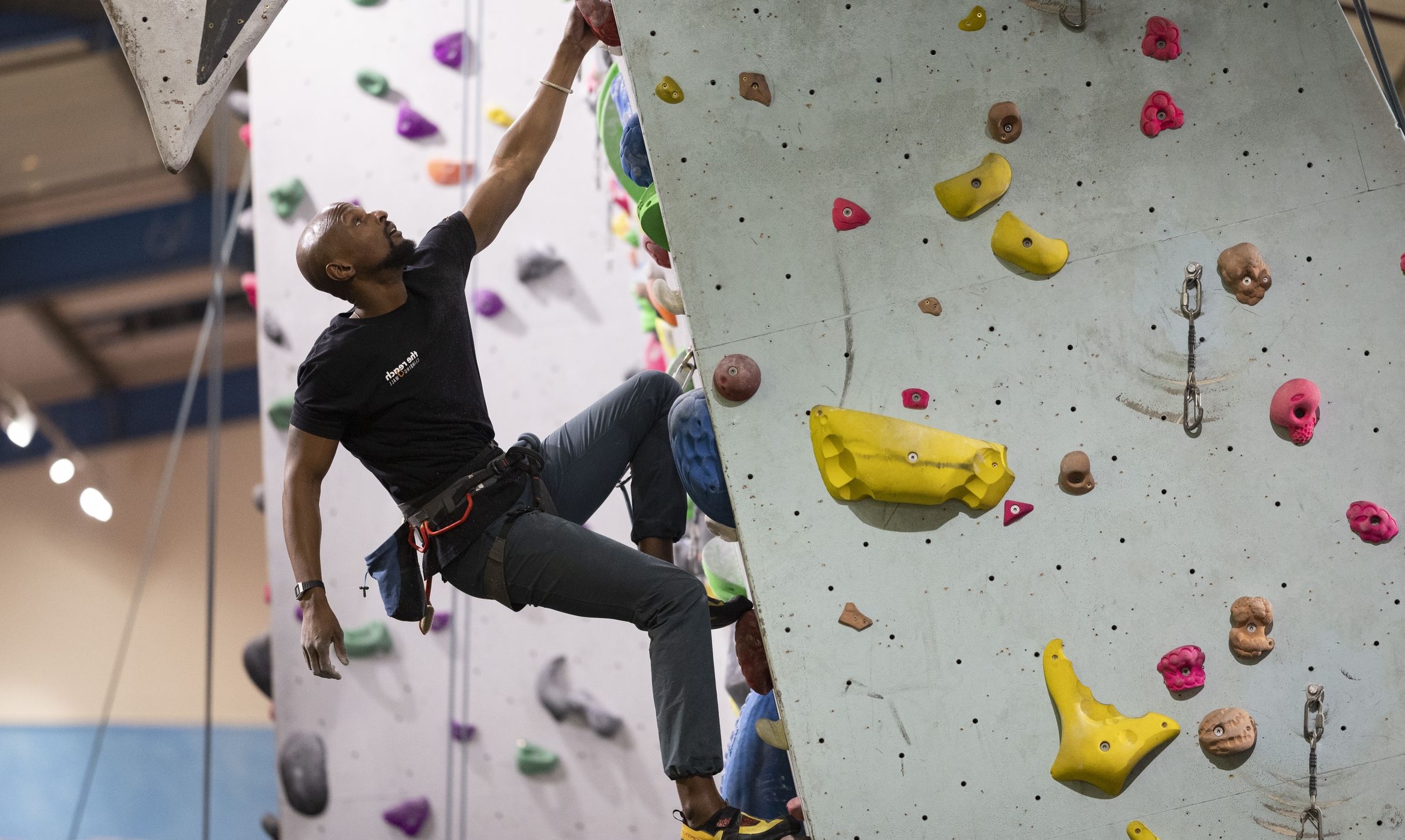 Climber hanging from one arm on an overhang 